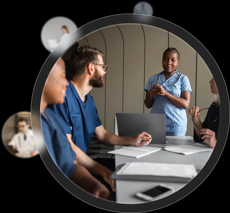 Clinical team collaborating during a GUIDE care coordination meeting, with one nurse standing at a laptop leading the discussion.