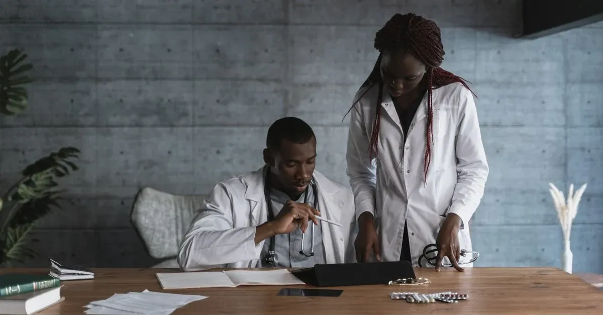 Two healthcare professionals reviewing cms access model documentation at wooden desk in modern office setting.