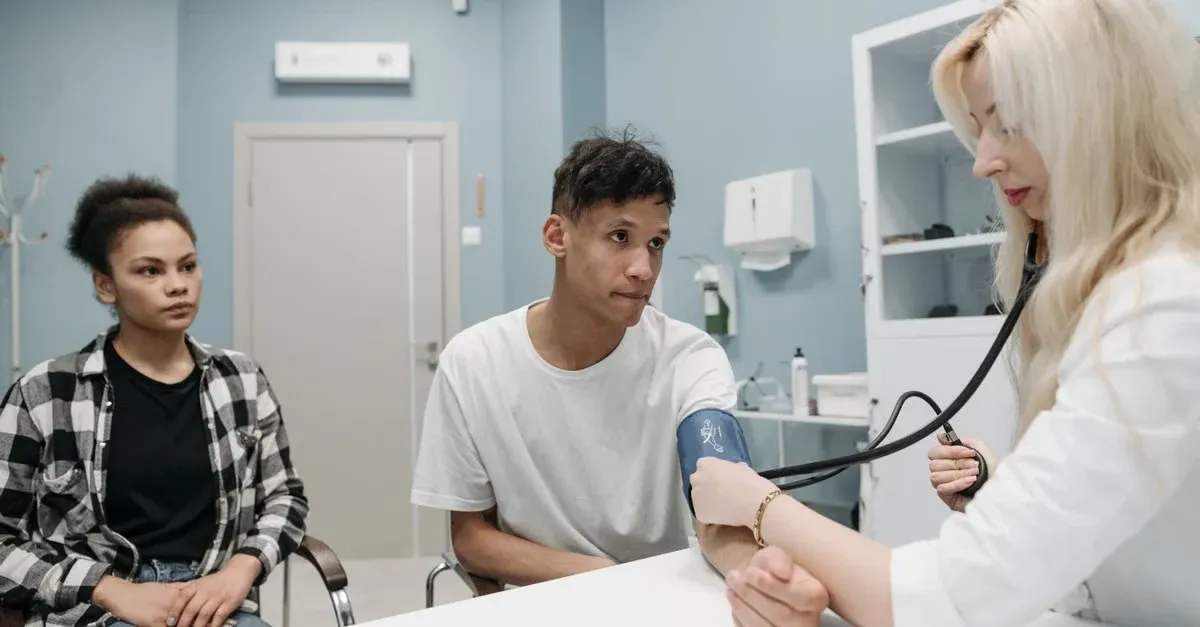 Doctor checking patient blood pressure during clinic visit to implement value based care approach.