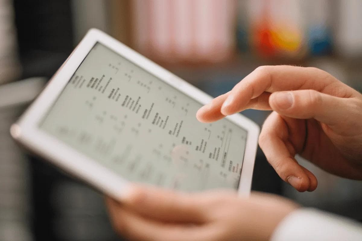 Close-up of hands navigating a tablet screen.