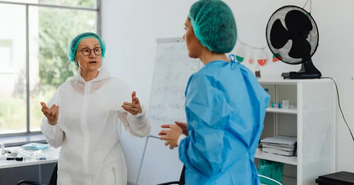 Two healthcare professionals discussing remote patient monitoring primary care strategy at whiteboard in modern clinic office.