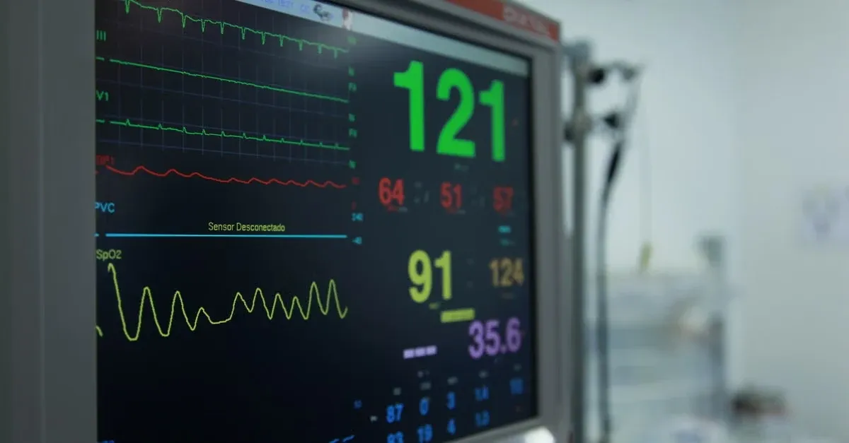 Medical monitor displaying vital signs with heart rate 121 bpm and oxygen levels, supporting APCM vs CCM protocols.