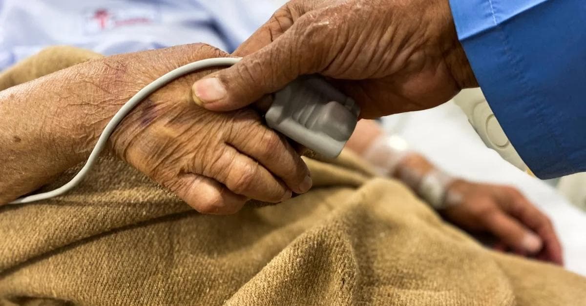 Healthcare provider checking patient's pulse with stethoscope for remote patient monitoring heart failure assessment.