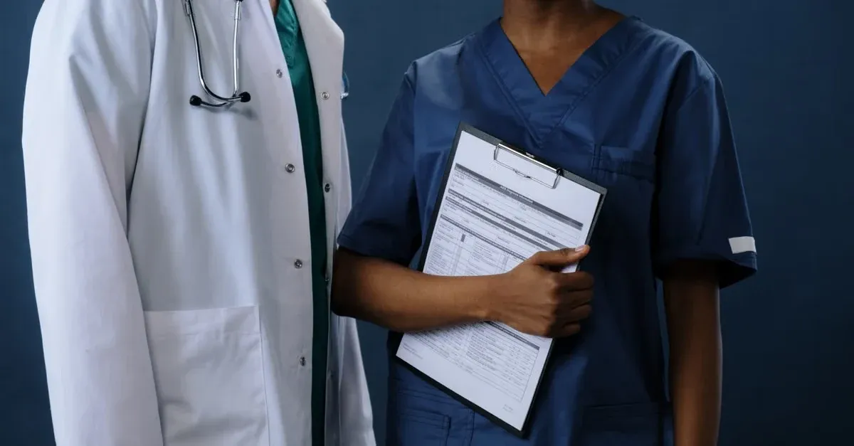 Doctor and nurse discussing patient medical records and APCM vs CCM care management protocols.