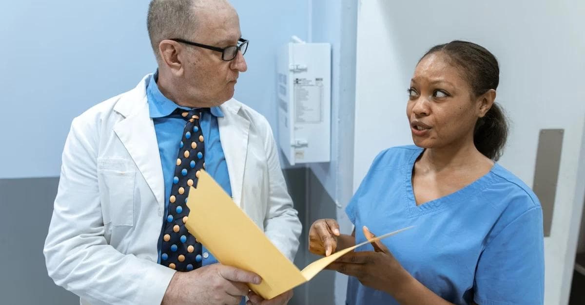Doctor and nurse reviewing chronic care management eligibility documents in medical clinic office setting