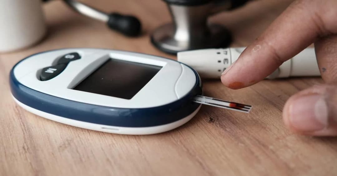Hand holding glucose meter showing blood sugar reading for chronic care management eligibility assessment