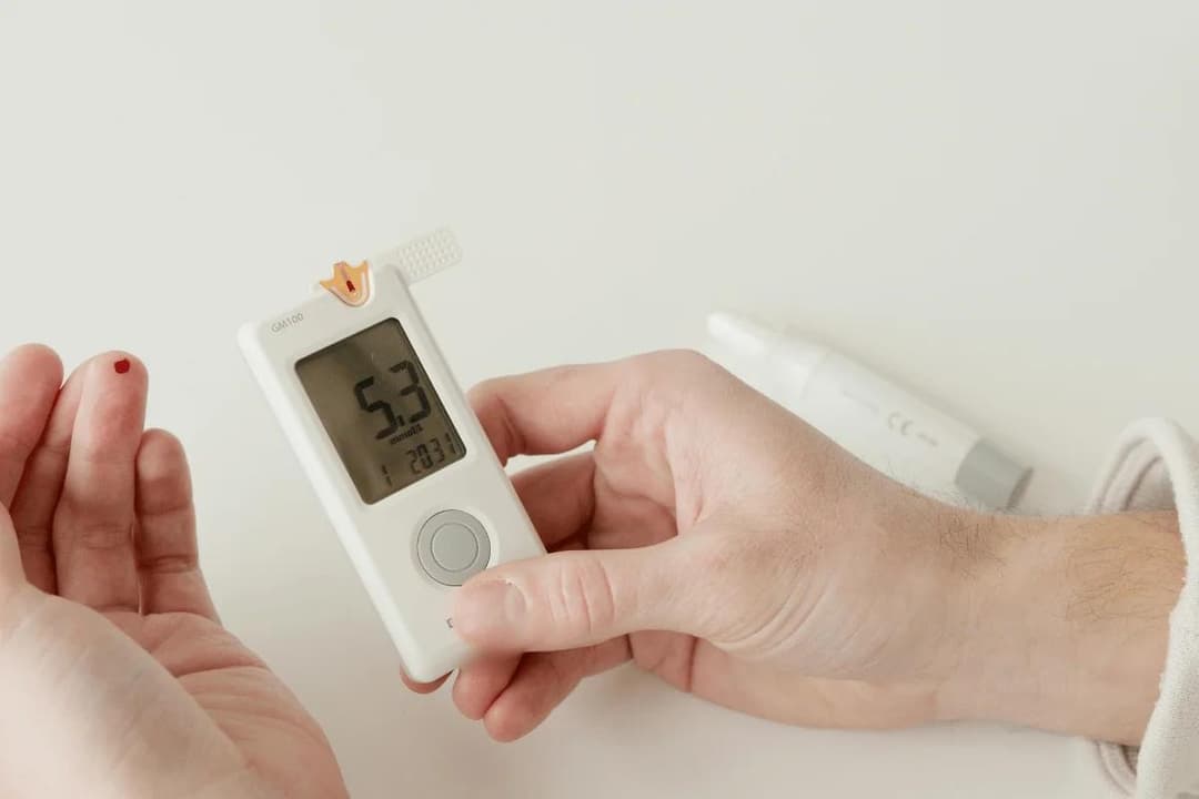 Person checking blood sugar with glucometer.