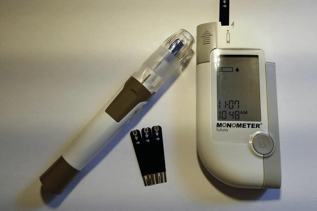 Blood glucose testing kit with lancing device, test strips, and digital monitor.