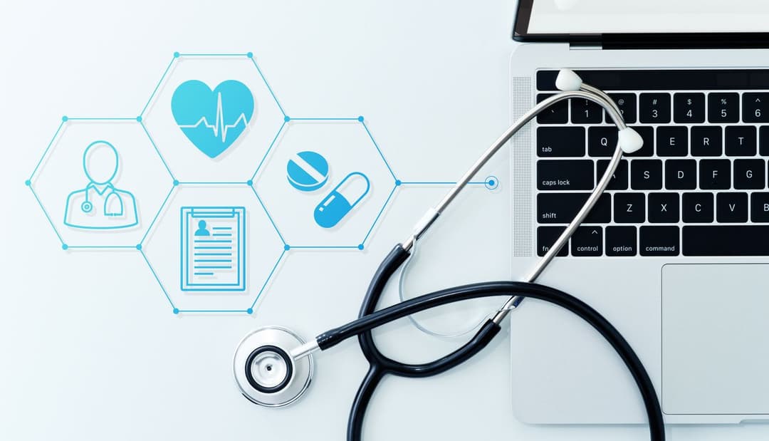 Stethoscope resting on a laptop keyboard with digital health icons representing remote patient monitoring, prescriptions, and medical records.