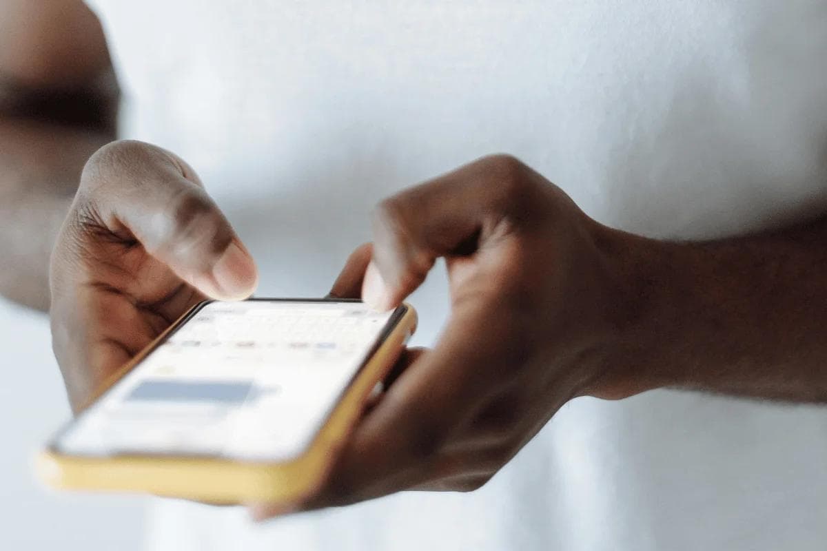 Close-up of person texting on smartphone with yellow case.