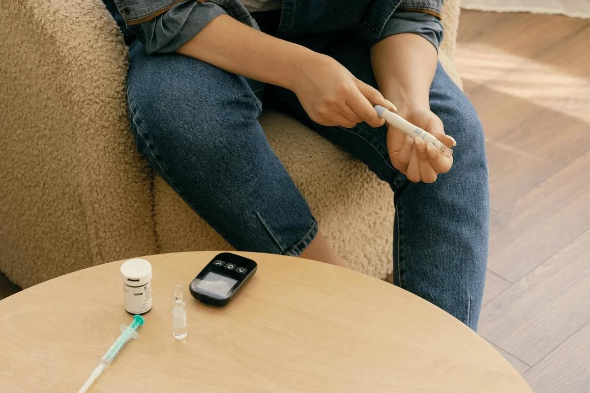 Person preparing an insulin pen for diabetes treatment at home.