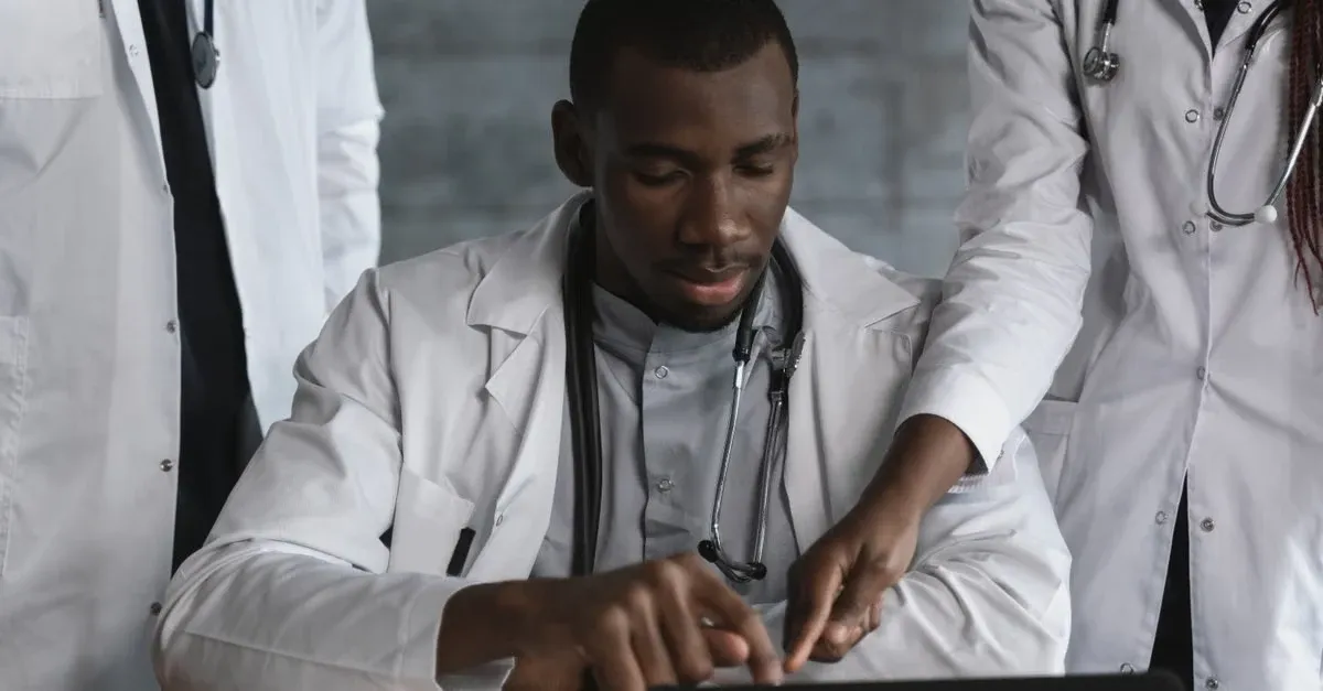 Healthcare professionals reviewing CCM documentation requirements on laptop together.