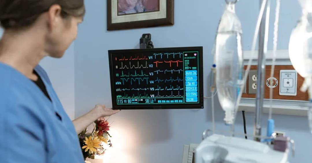 Healthcare provider monitoring patient vital signs on digital display for reducing hospital readmissions.