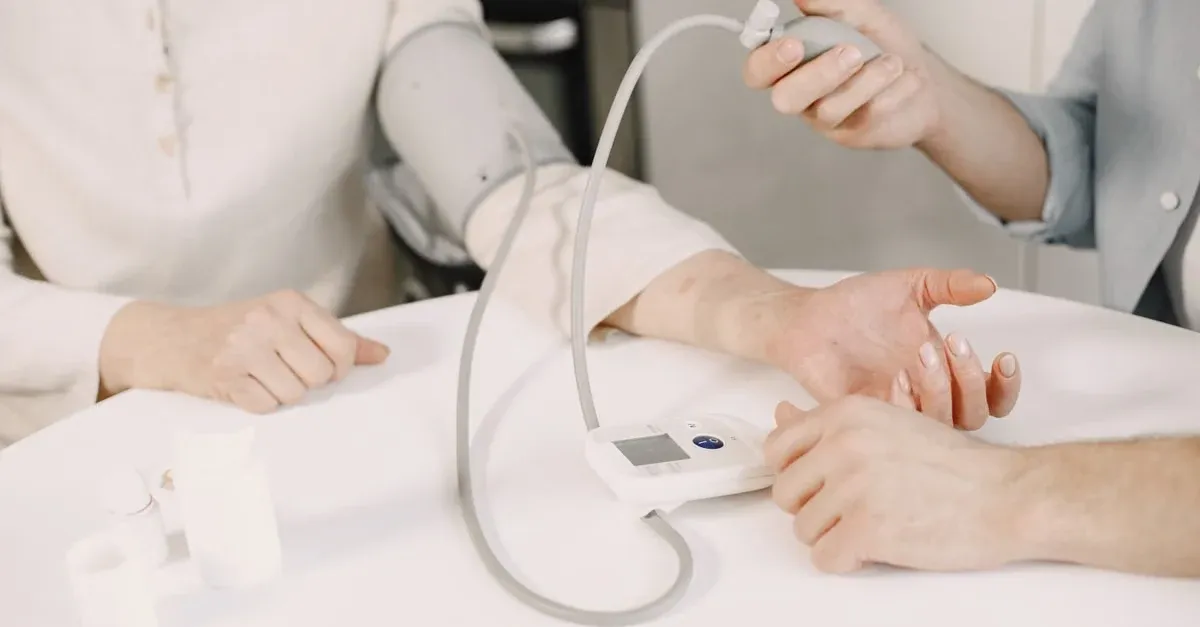 Patient checking blood pressure on a connected monitor that transmits readings to a KangarooHealth care team dashboard.