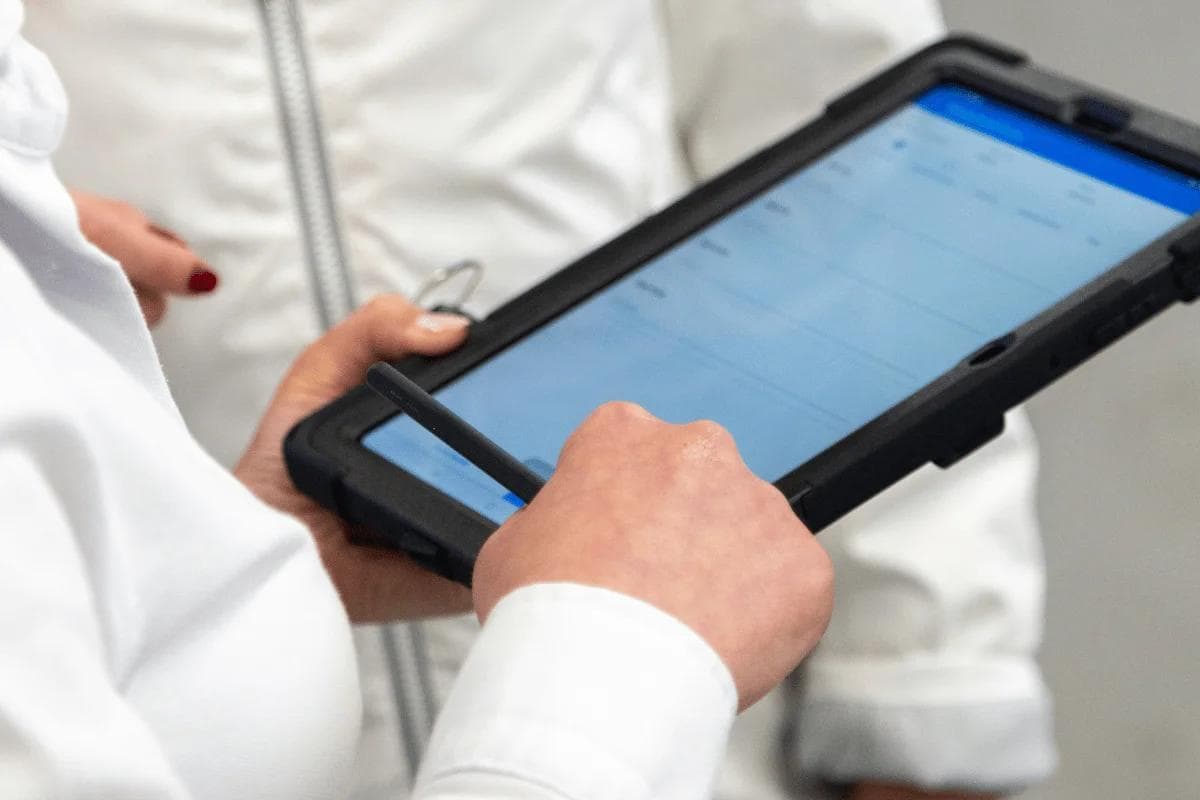 Person using a digital tablet with a stylus pen.