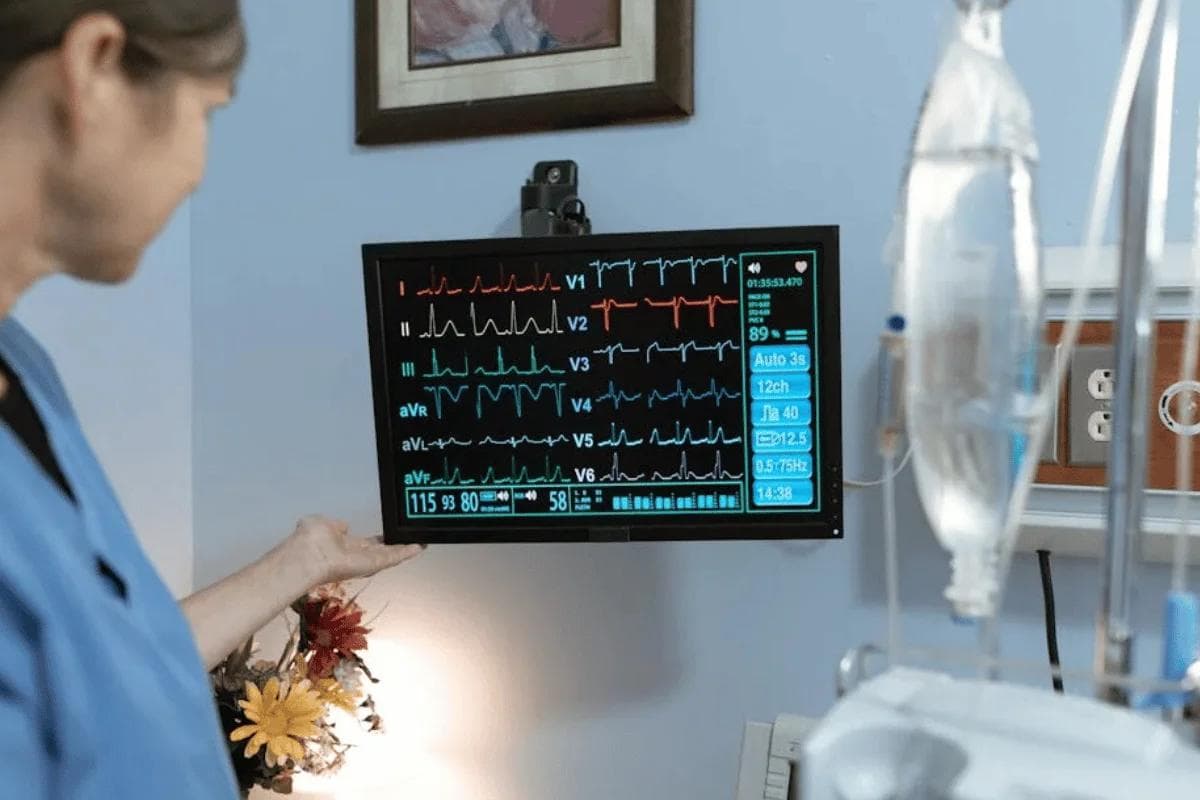 Healthcare professional monitoring patient data on digital screen showing fee for service vs value based care metrics.