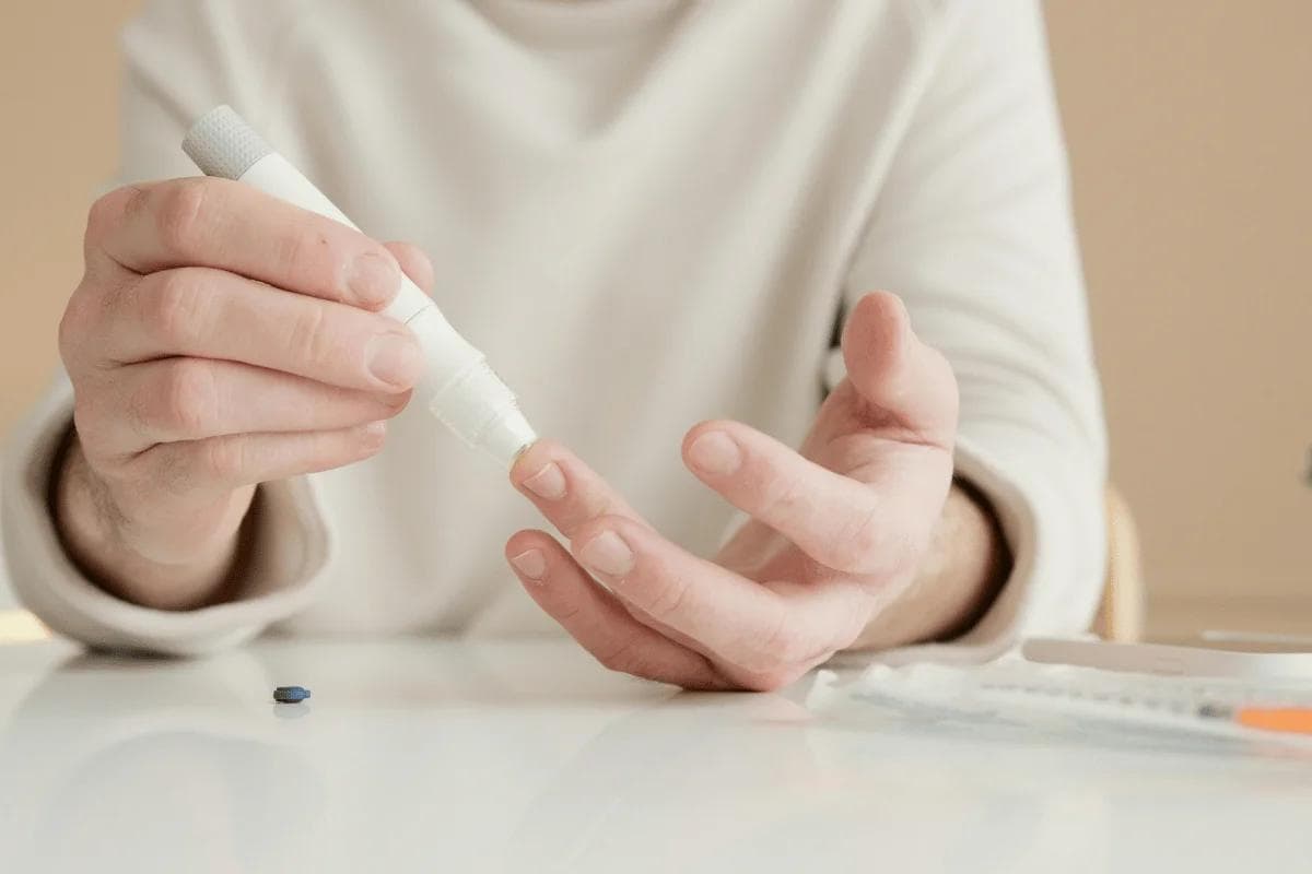 Person using a lancing device to test blood sugar.